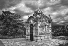 A small chapel near Stemnitsa in Greece in black and white with a dramatic sky